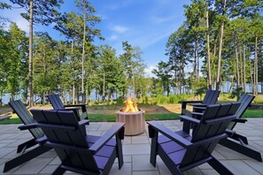 An outdoor seating area with four Adirondack chairs and a central fire pit. - Luxury New Build with Lake Norman Views & Resort Amenities- Sleeps 16 (Lake Norman of Catawba)