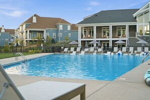 A swimming pool with lounge chairs and umbrellas, surrounded by residential buildings. - Luxury New Build with Lake Norman Views & Resort Amenities- Sleeps 16 (Lake Norman of Catawba)