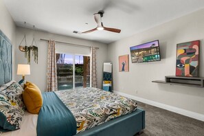 A bedroom with a bed, a ceiling fan, a TV, and artwork on the wall. - Entire Home + Private Casita | Private Pool & Spa | Putting Green | Fully Fenced Yard| Community Amenities (Palm Springs)