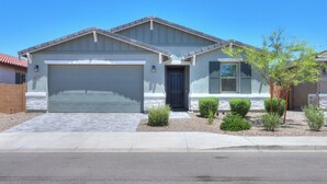 Ein Wohnhaus mit Garage, Eingangstür und kleinem Vorgarten mit Bepflanzung.