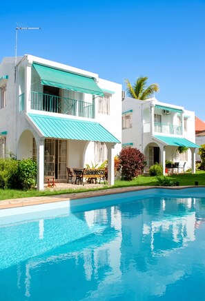 A two-story building with a swimming pool in front.