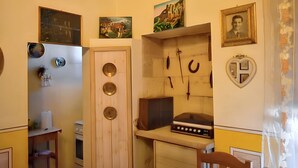 Uma cozinha compacta com fogão, pia e diversos utensílios.