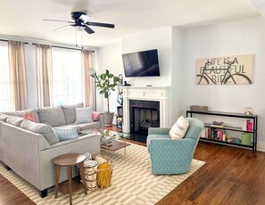 A living room with a sofa, armchair, coffee table, and a fireplace. - Rocky Branch Retreat (Belmont)