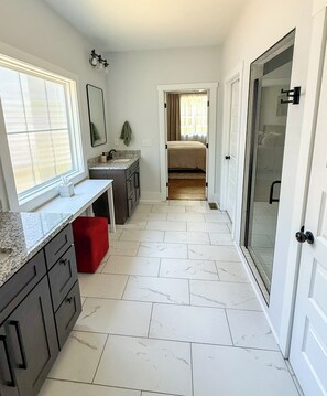 A narrow hallway with a kitchen area on one side and a bedroom on the other, featuring a double door and a window with blinds. - Rocky Branch Retreat (Belmont)