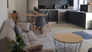 Ein modernes Wohnzimmer mit einer Couch, einem Couchtisch und einem Essbereich mit Stühlen.