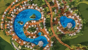 Ein Resort mit mehreren Schwimmbecken, Liegestühlen und Palmen.