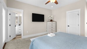 A bedroom with a bed, a dresser, a television, and a ceiling fan. - Private Pool House — 5BR/5BA in Surfside Beach, Steps to the Beach (Surfside Beach)