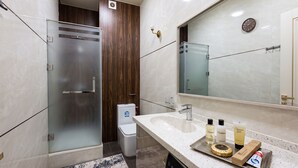 A modern bathroom with a glass shower enclosure, a sink with toiletries, and a large mirror. - Fabulous 2-bedroom apartment with AC in charming Toshkent (Тоshkent)