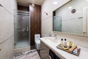 A modern bathroom with a glass shower enclosure, a sink with toiletries, and a large mirror. - Fabulous 2-bedroom apartment with AC in charming Toshkent (Тоshkent)