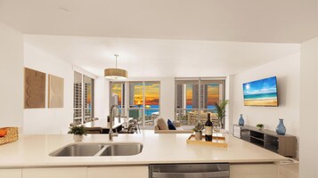 A modern kitchen with a large island, a dining area with a view, and a living space with a TV.