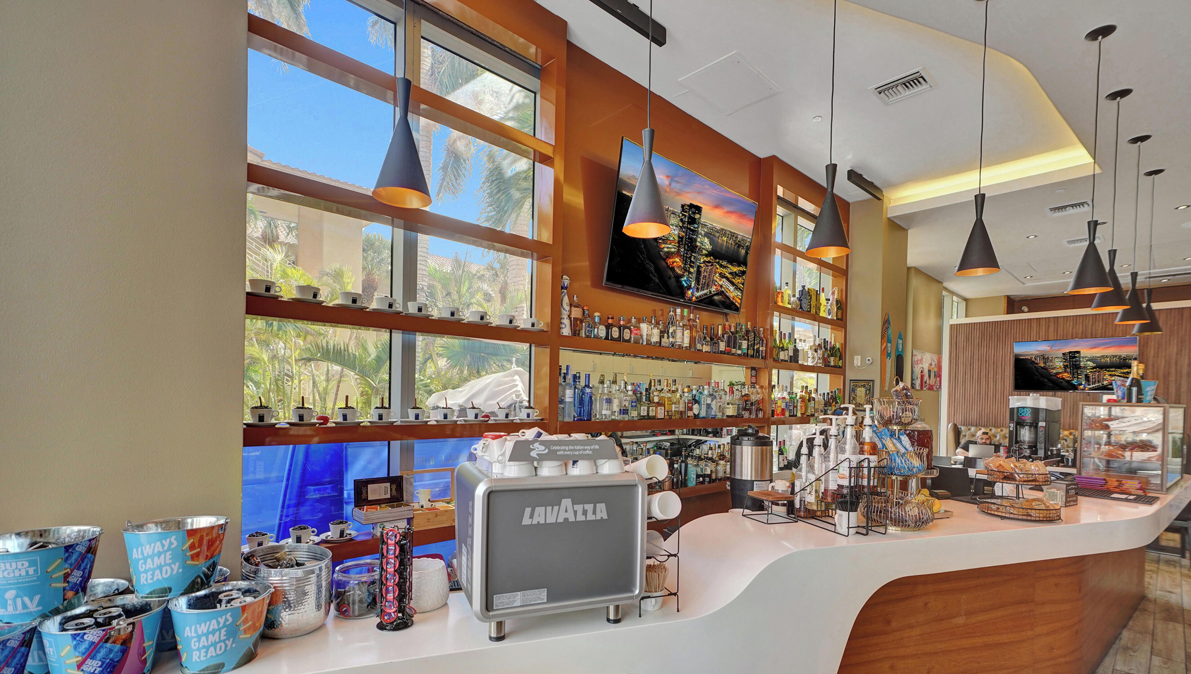 A bar area with a counter, shelves with bottles, and a coffee machine.