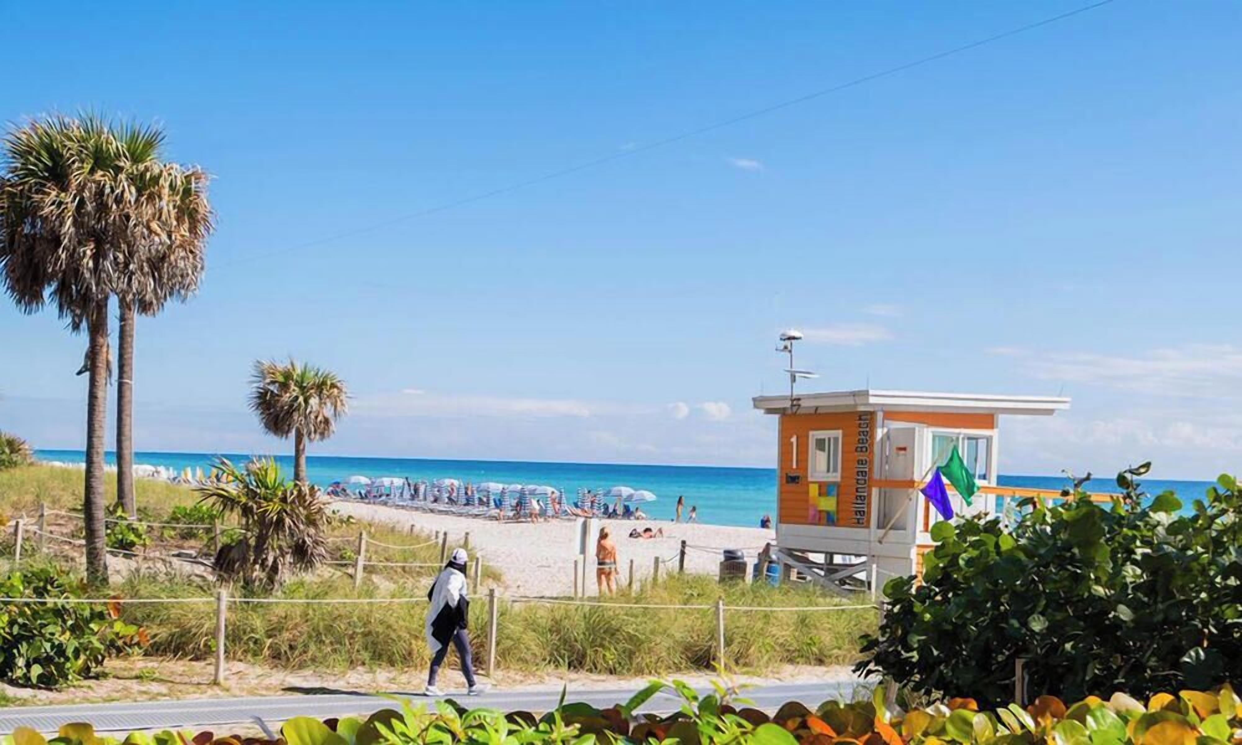 A beachside lifeguard tower with a clear view of the ocean and beachgoers.
