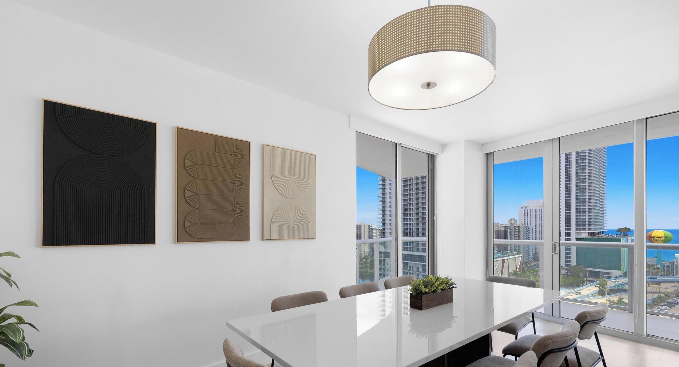 A modern conference room with a large table, chairs, and artwork on the wall.