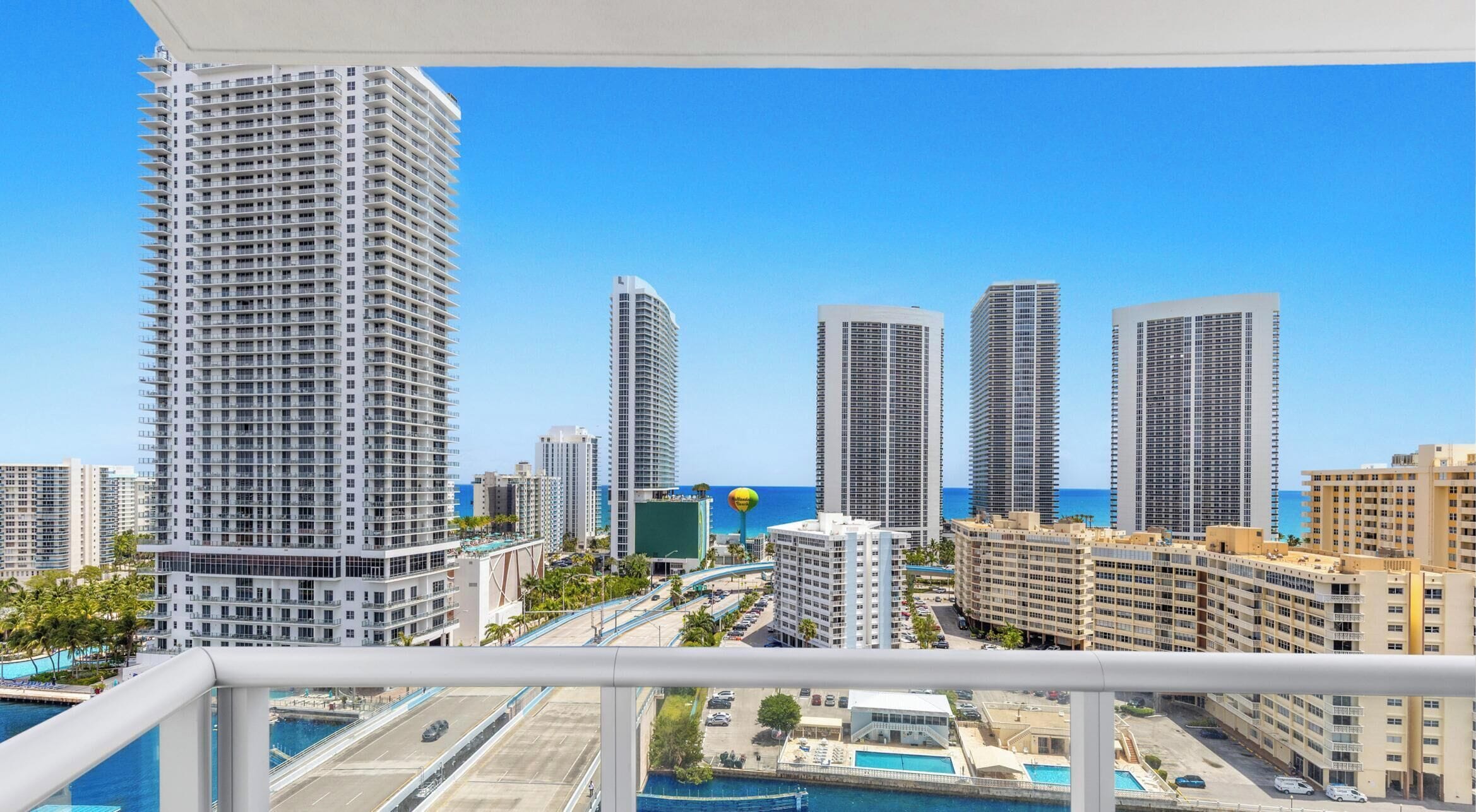 A high-rise building with a view of the ocean and other buildings.