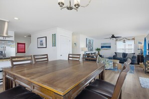A spacious living area with a dining table, chairs, a sofa, and a ceiling fan. - Dog-friendly oceanfront escape (North Topsail Beach)