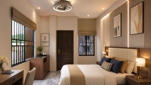 Een hotelkamer met een bed, nachtkastje, lamp, bureau, stoel en uitzicht door het raam.