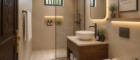 A modern bathroom with a vanity, toilet, and shower.