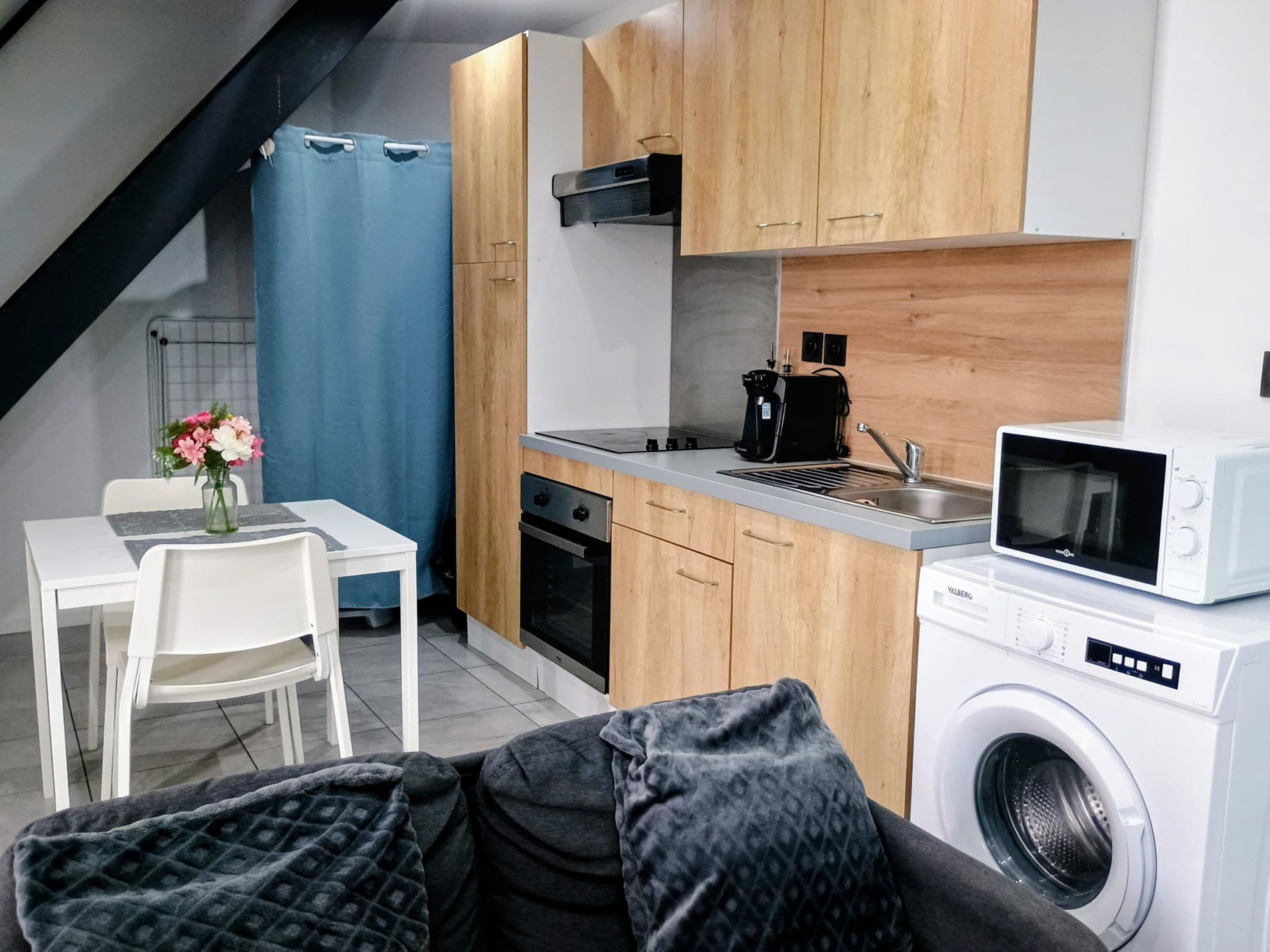 Een kleine keuken met een magnetron, oven en koffiezetapparaat.