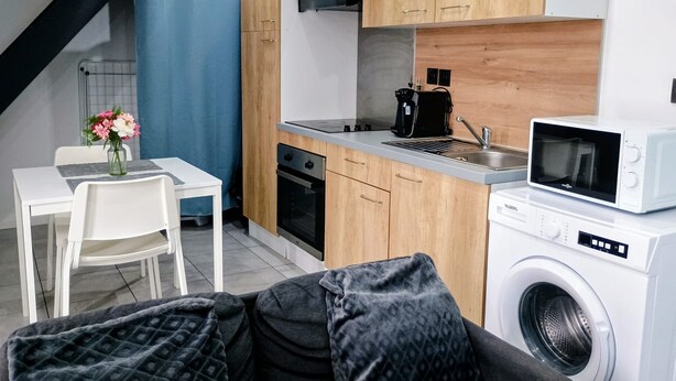 Eine kleine Küche mit Mikrowelle, Backofen und Kaffeemaschine.