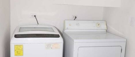 A laundry room with a front-loading washer and a top-loading dryer.