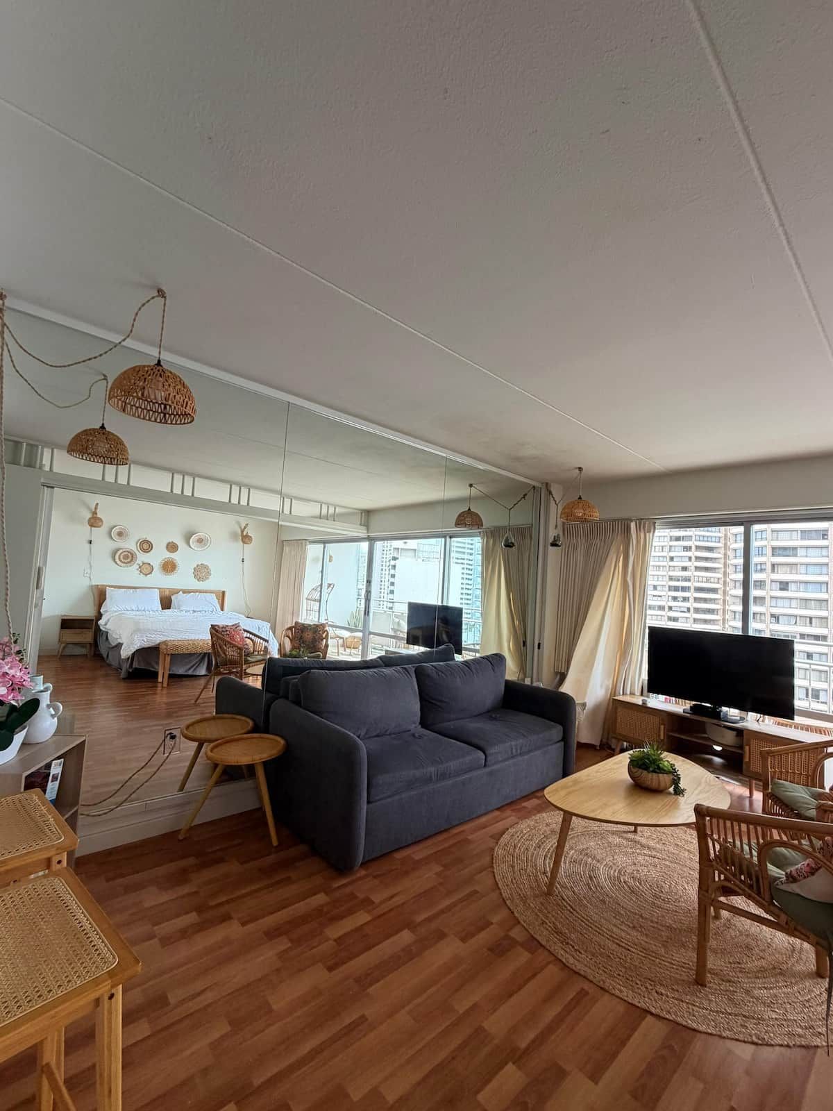 Una sala de estar moderna con sofá, televisor y comedor.