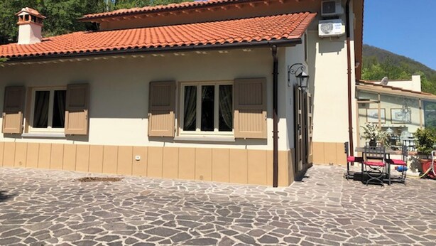 A building with a tiled roof, windows with shutters, and a stone-paved ground. - Homerez - House in Gattaia with pool (Gattaia)