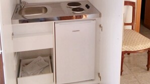 Una kitchenette compacta con pileta, estufa y alacenas.