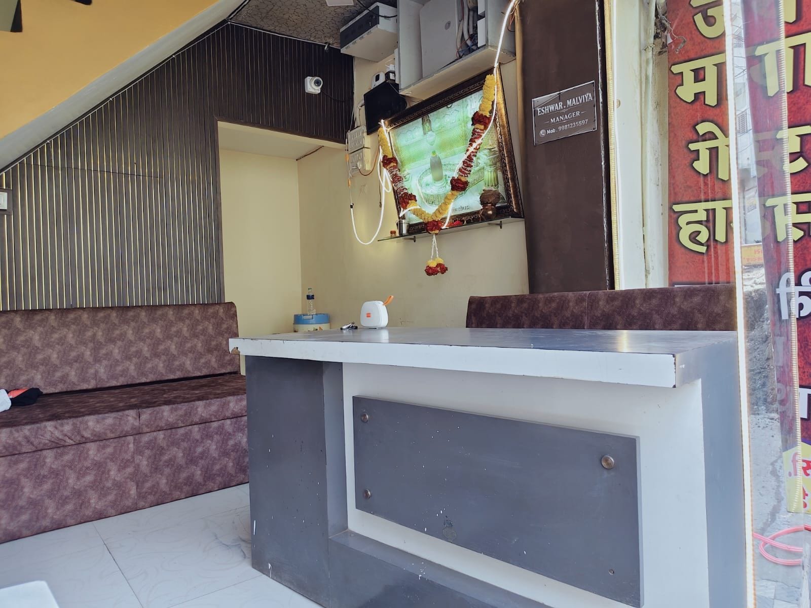A reception desk with a computer monitor, a telephone, and a water dispenser.
