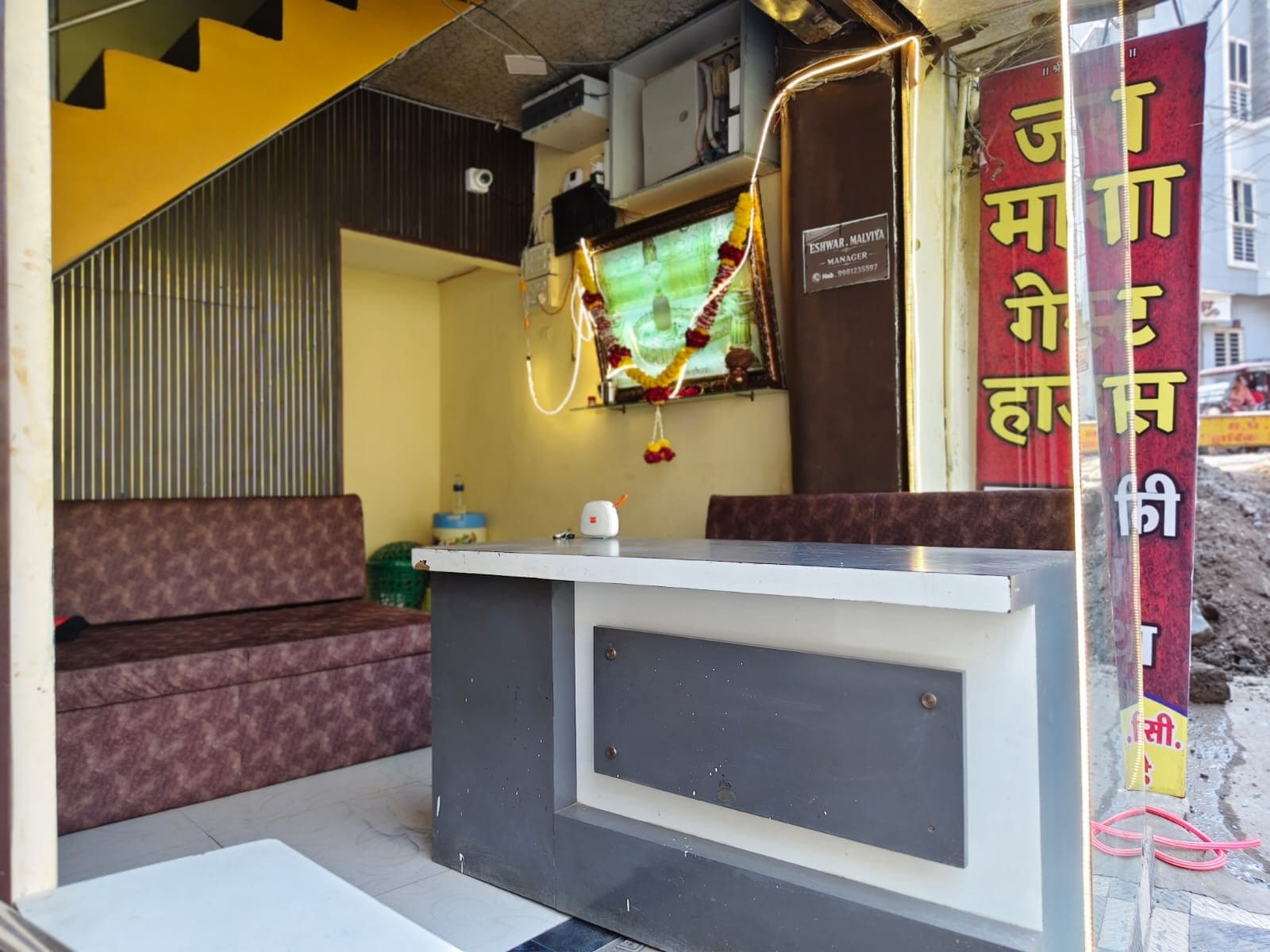 A reception area with a counter, a bench, and a wall-mounted sign.