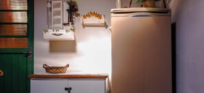 Uma cozinha com geladeira, pia e janela com vista para o exterior.