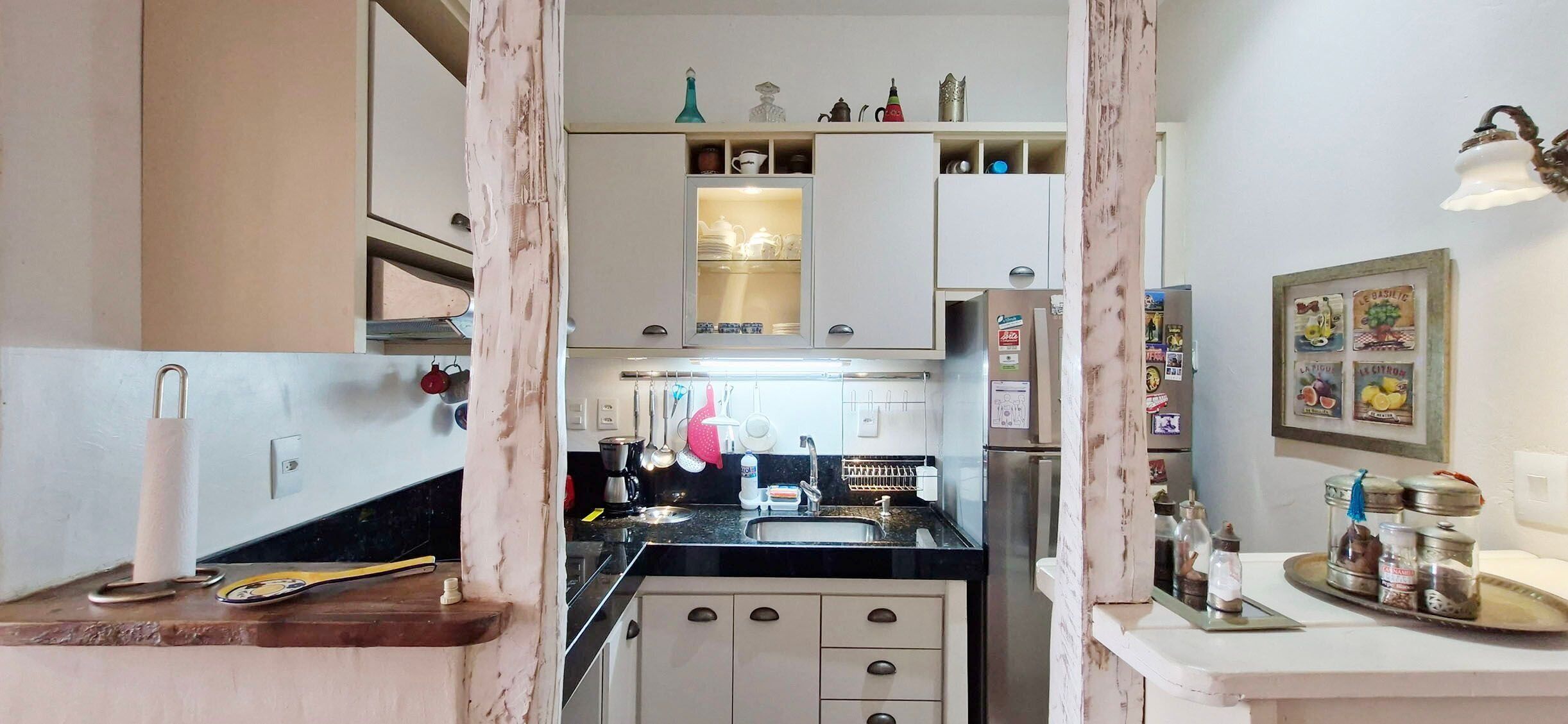 Una cocina compacta con una isla central, armarios y diversos utensilios.