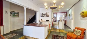 A hotel lobby with a reception desk, a staircase, and a dining area. - COPEL0100 - Prédio 34 (Salvador)