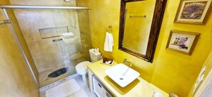 A bathroom with a glass shower enclosure, a toilet, a sink with a mirror, and a towel rack. - COPEL0100 - Prédio 34 (Salvador)