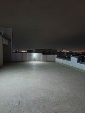 A rooftop terrace with a view of the city skyline at night. - Adorable 1-bedroom apartment in Nairobi 20 mins drive from JKIA welcome (Nairobi)