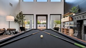 Ein Billardtisch in einem modernen Raum mit Blick ins Freie.