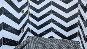 Ein Badezimmer mit einem schwarz-weißen Zickzackmuster auf Wänden und Boden.