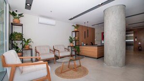 Ein modernes Interieur mit einer Rezeption, einer Sitzgruppe und einer großen Säule.
