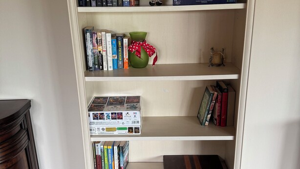 A bookshelf with various books, a decorative vase, and a small figurine. - 2 Masters,4 bedrooms total, 2 Kitchens, 3 Living Areas,Hot Tub, Game RM & Gym (Lake Stevens)