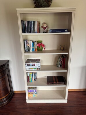Een boekenplank met verschillende boeken, een decoratieve vaas en een klein beeldje.
