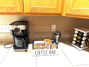 Eine Küche mit einer Kaffeemaschine, einem Schild für eine Kaffeebar und einem Gewürzregal.