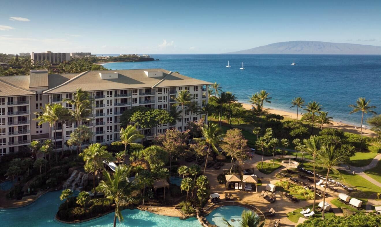 A resort with multiple buildings, a pool area, and a beach.