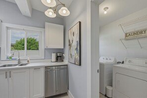 A modern kitchen with a built-in dishwasher, a coffee maker, and a sink with hand soap. - Waterfront Fun & Mini Golf, Heated Salt Water Pool & Game Room (Port Charlotte)