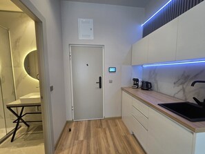 Una cocina moderna con horno empotrado, cafetera y pileta.