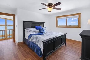 A bedroom with a bed, a ceiling fan, a window, and a view of the ocean. - Lake FRONT-3 Story-Sleeps 12-Game FLOOR-Free Kayaks! (Canyon Lake)