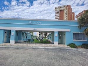 Un hôtel appelé Monterey, doté d’un espace extérieur couvert avec des sièges et d’une entrée bien visible.