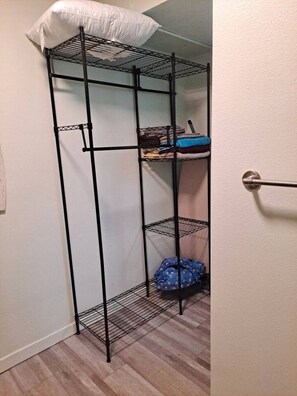 Un lit superposé avec une structure en métal, un oreiller sur le lit du haut et une porte avec une poignée.