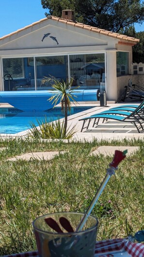 Un espace piscine avec des chaises longues et un coin salon abrité.