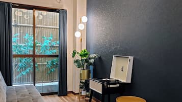 Una sala de estar moderna con un sofá, una mesita con una lámpara, una planta en maceta y un aire acondicionado instalado en la pared.