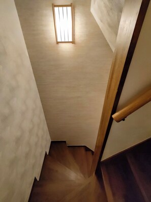 Una escala de fusta amb un petit finestre a la part superior.