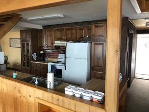 Eine Küche mit Holzschränken, einem weißen Kühlschrank und einem Spülbecken.